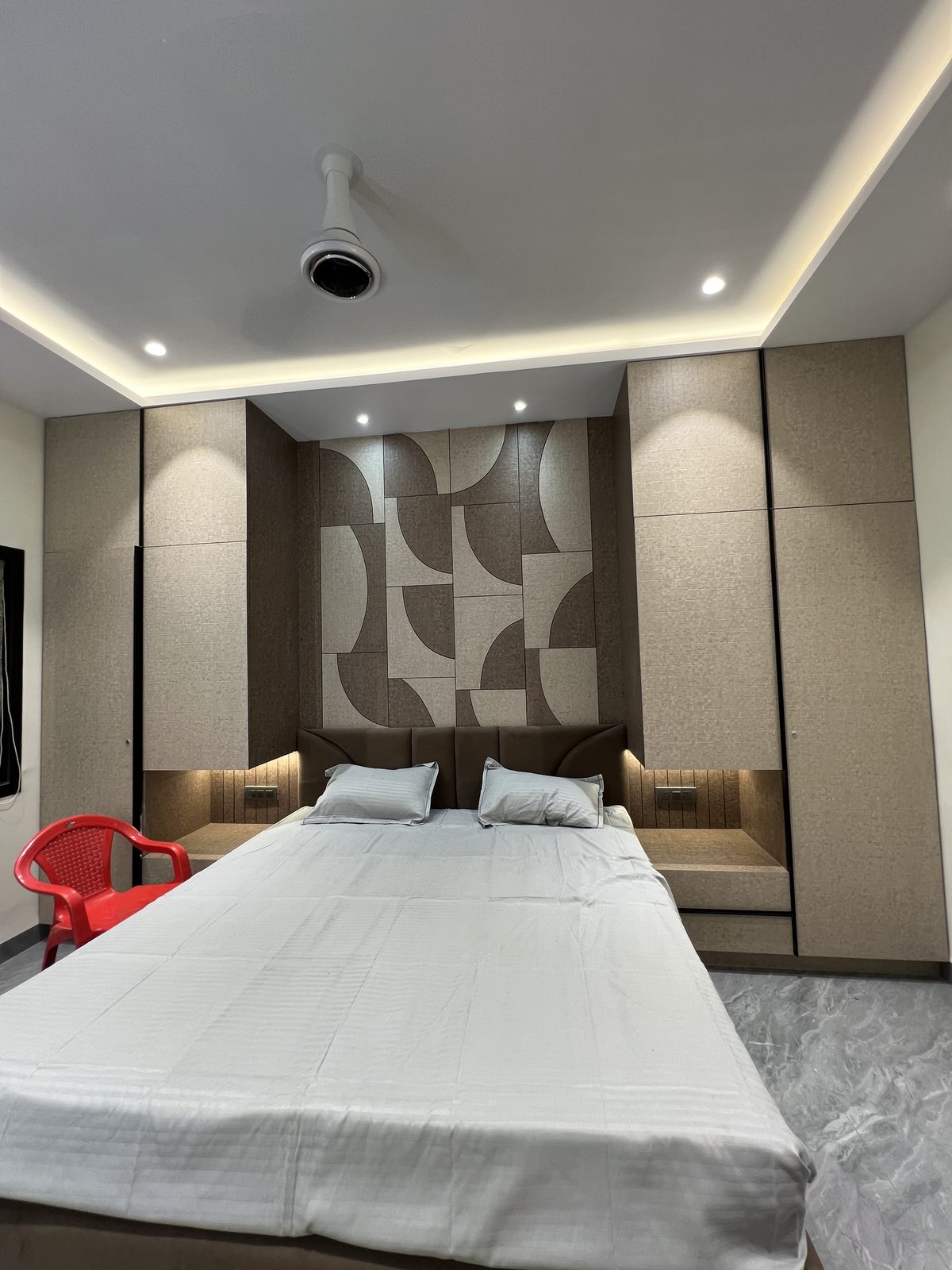 Bedroom with geometric patterned headboard panel and built in side storage, Latur