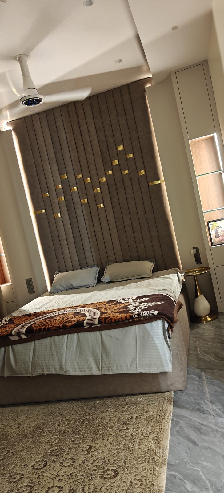 Double bed with matching bedside table and backlit wall panelling in a master bedroom, Udgir