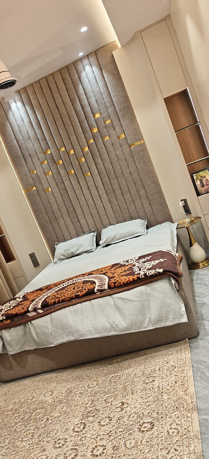 Full height fluted wall panel with brass inlay pattern behind a bed, Udgir
