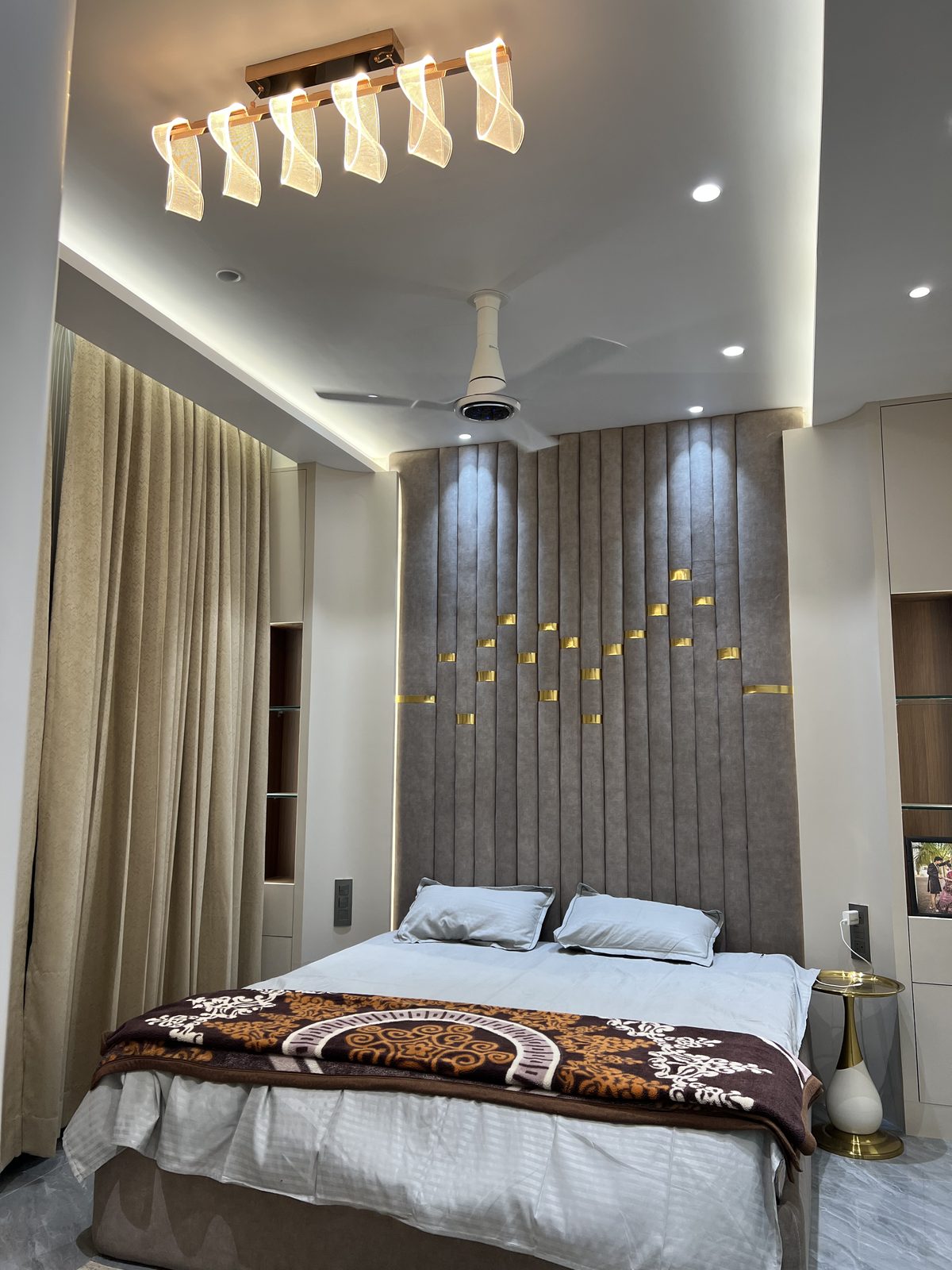 Master bedroom with fitted storage, display niches and brass inlay wall panel, Udgir