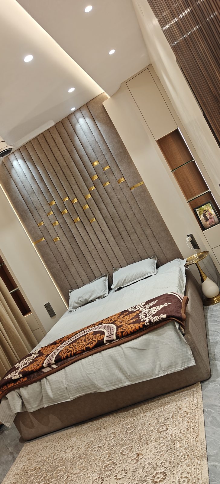 Modular double bed with brown fluted wall panel headboard and brass inlay detailing, Udgir