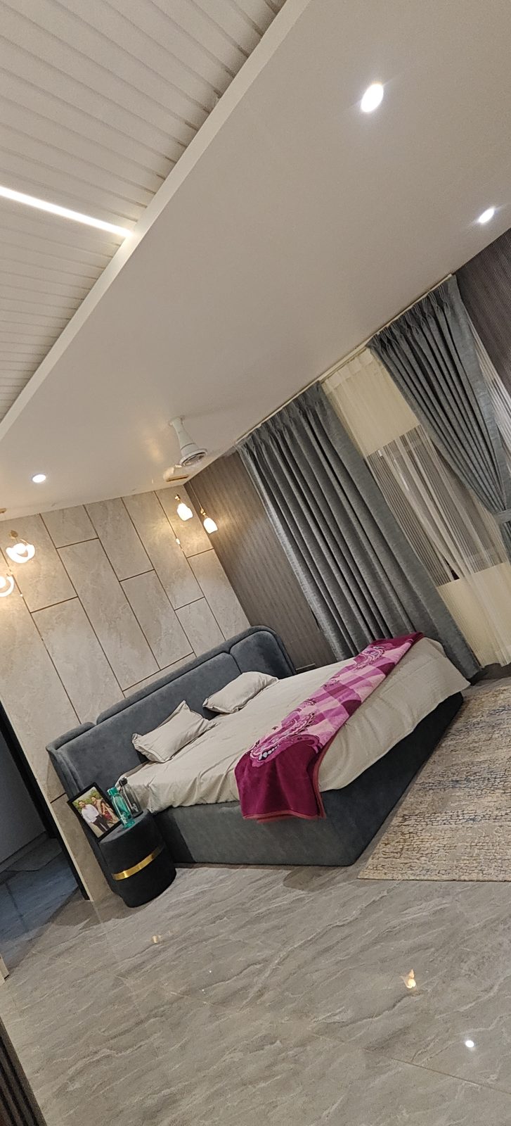 Platform bed on polished marble flooring with a textured feature wall behind, Udgir