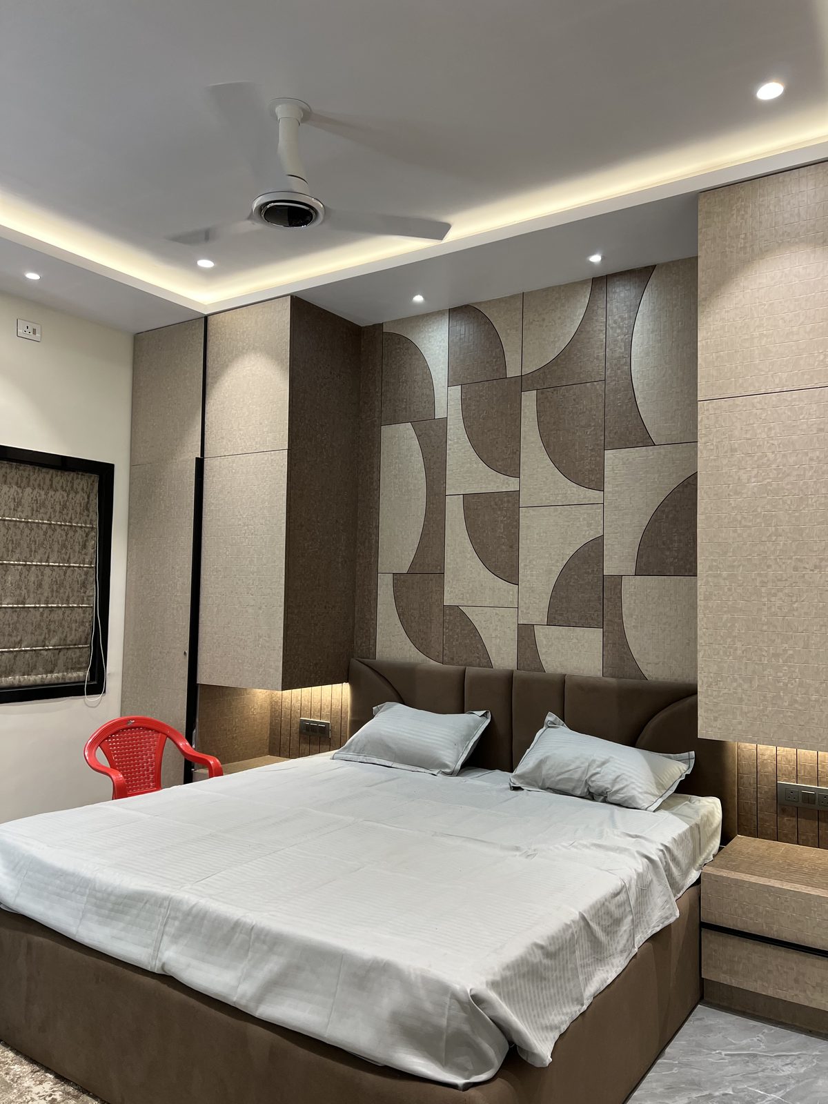 Decorative wall unit with geometric patterned panels flanked by fitted storage, Udgir